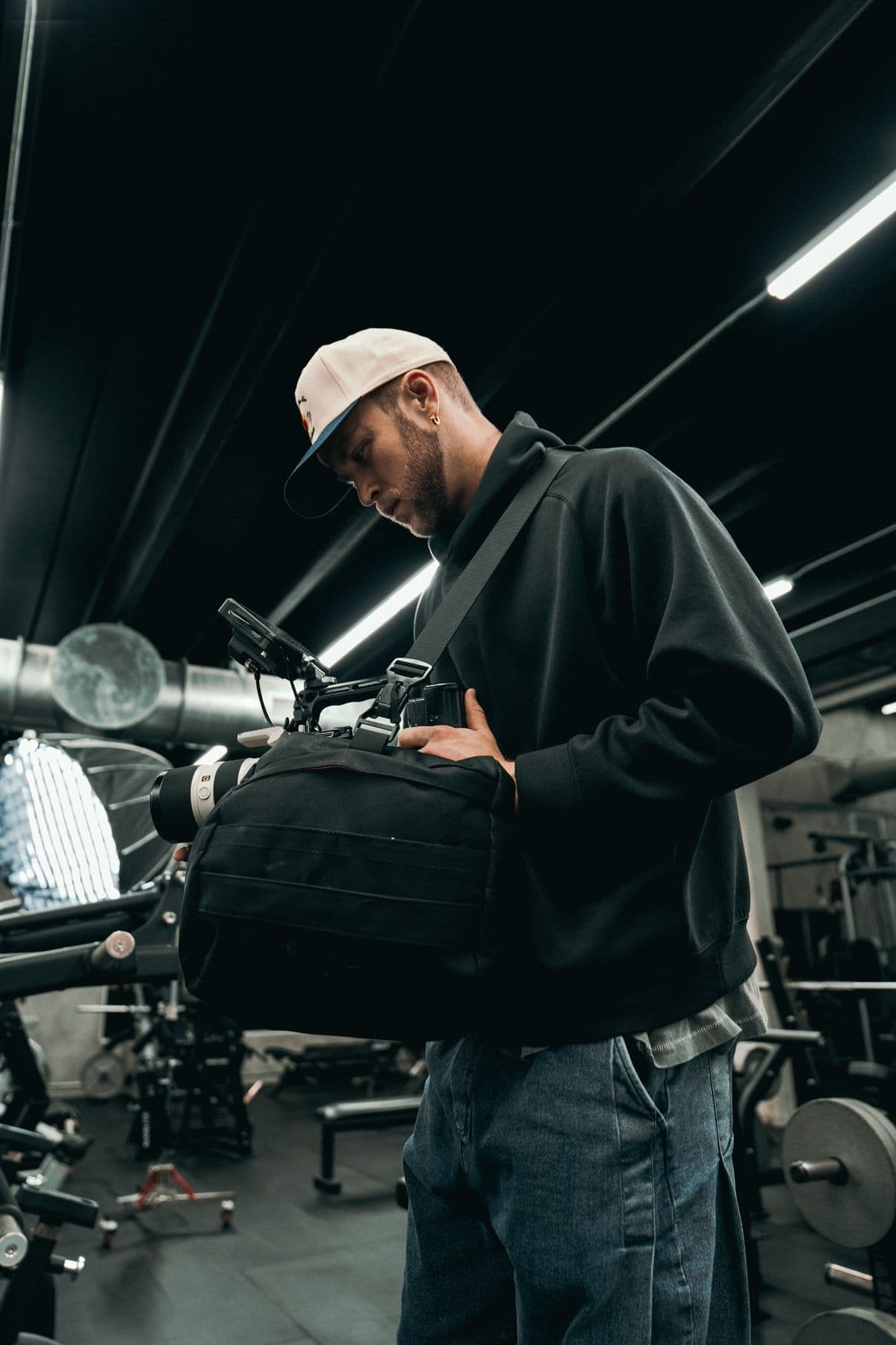 A cinematographer adjusting camera equipment indoors.