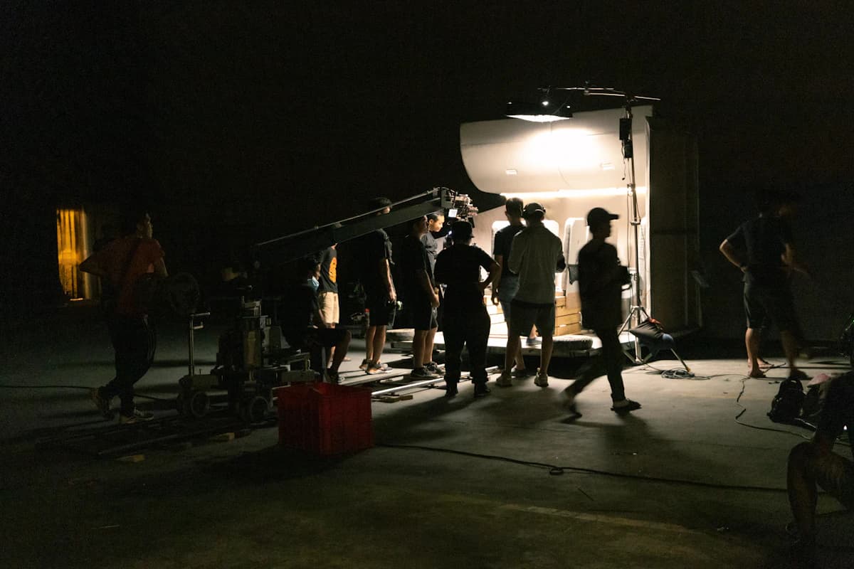 A film crew gathered around a camera in the dark.