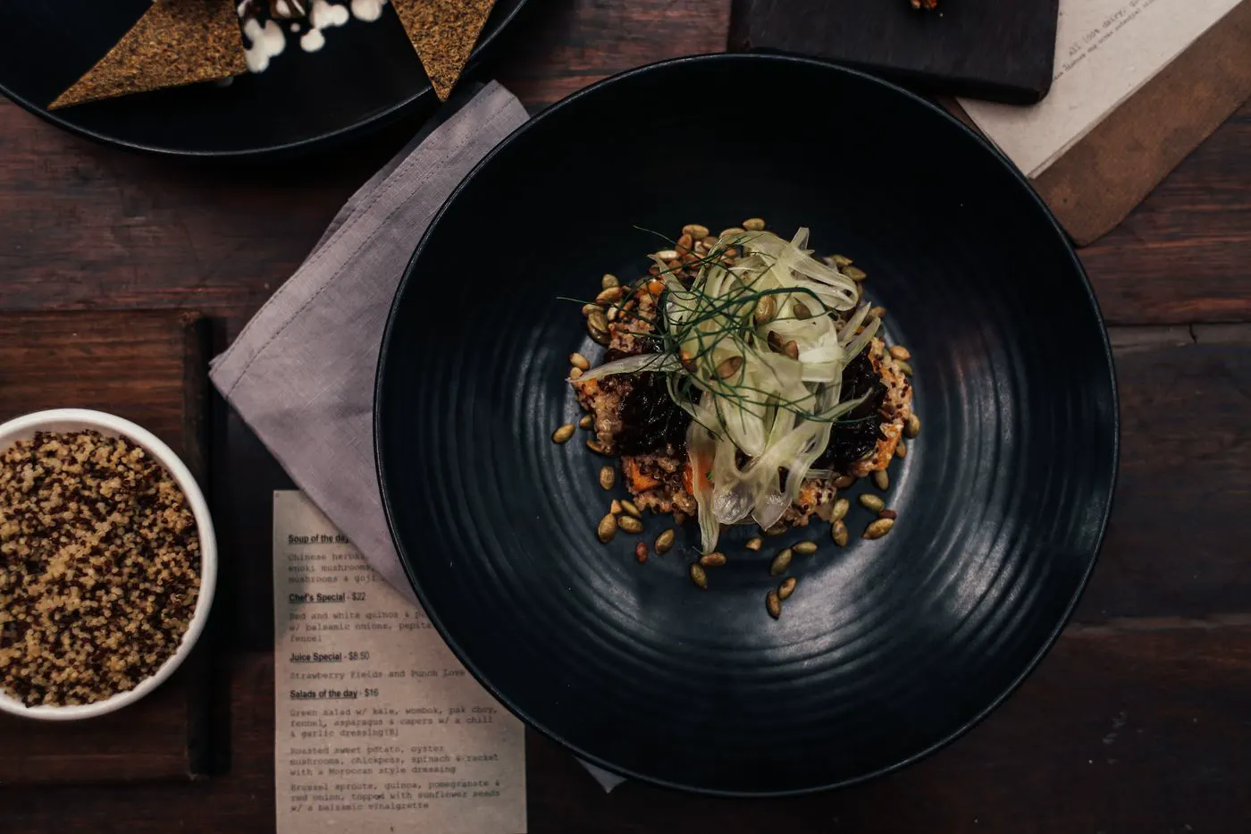 A grain and vegetable dish on a black ribbed plate.